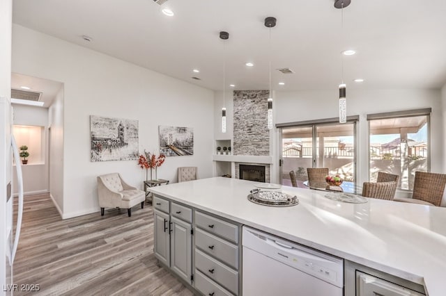 kitchen featuring a fireplace, dishwasher, lofted ceiling, gray cabinets, and pendant lighting