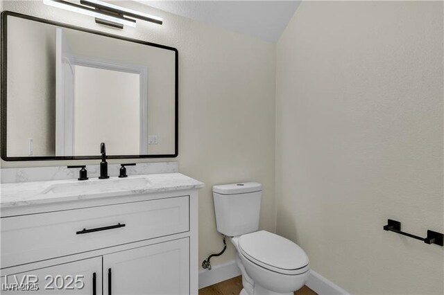 bathroom with vanity, toilet, and vaulted ceiling