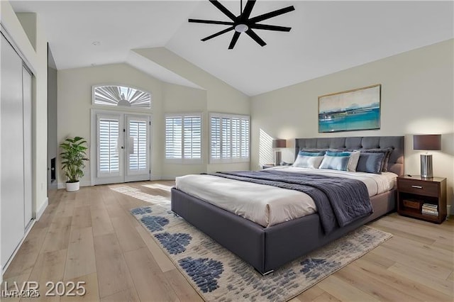 bedroom with ceiling fan, vaulted ceiling, light hardwood / wood-style flooring, and french doors