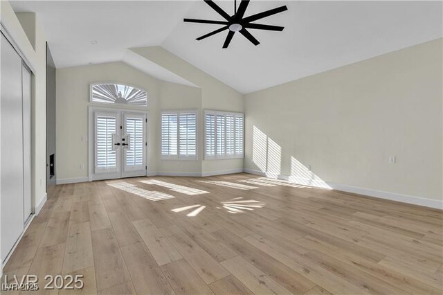 unfurnished living room with french doors, light hardwood / wood-style floors, vaulted ceiling, and ceiling fan