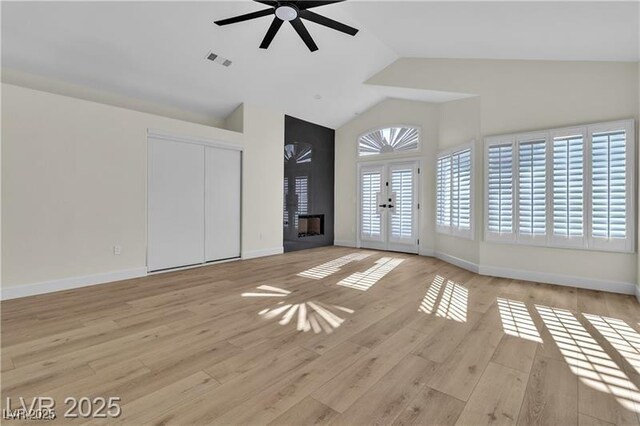 unfurnished living room featuring french doors, light hardwood / wood-style flooring, ceiling fan, and lofted ceiling