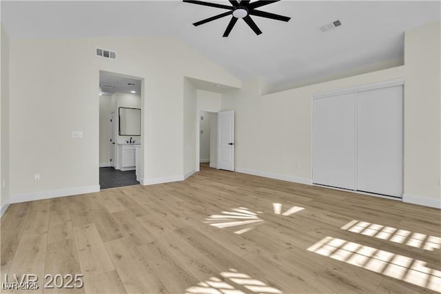 unfurnished bedroom with vaulted ceiling, ceiling fan, light hardwood / wood-style flooring, connected bathroom, and a closet