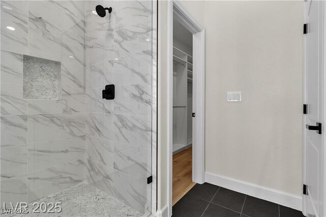 bathroom with tile patterned floors and tiled shower