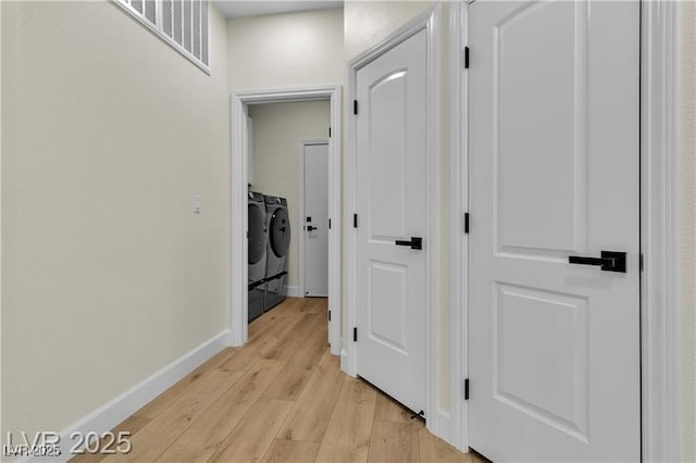 hall featuring washer and clothes dryer and light hardwood / wood-style flooring