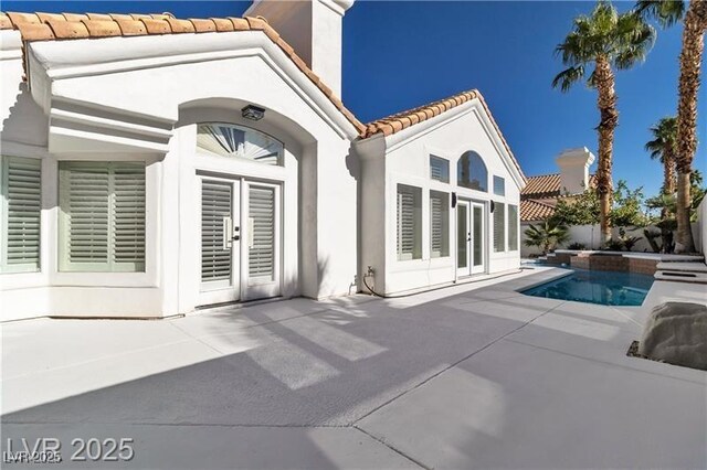 back of property with french doors and a patio