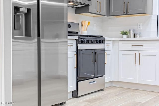 kitchen with white cabinets, gray cabinets, appliances with stainless steel finishes, and light hardwood / wood-style flooring