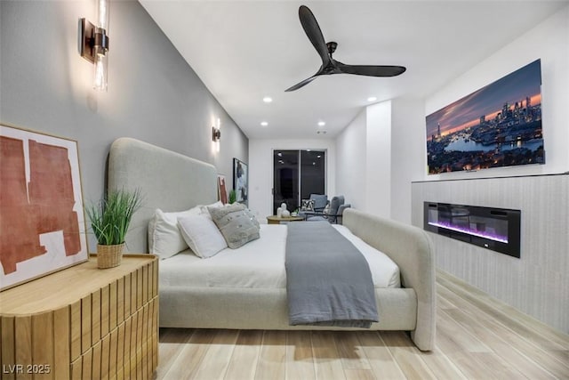 bedroom featuring ceiling fan, radiator heating unit, and hardwood / wood-style flooring