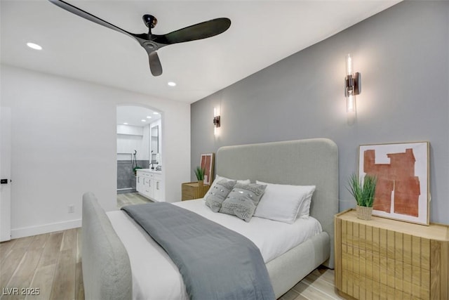 bedroom with ensuite bathroom, ceiling fan, and light hardwood / wood-style floors