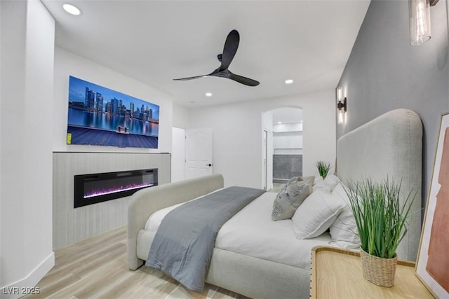 bedroom featuring ceiling fan, wood-type flooring, and connected bathroom