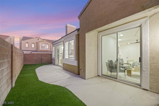 yard at dusk featuring a patio area