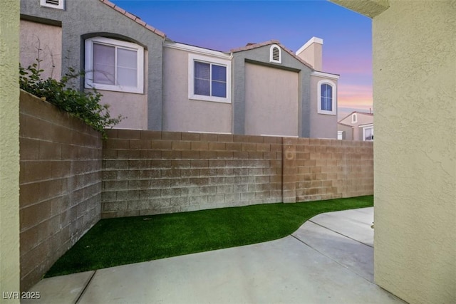 yard at dusk featuring a patio