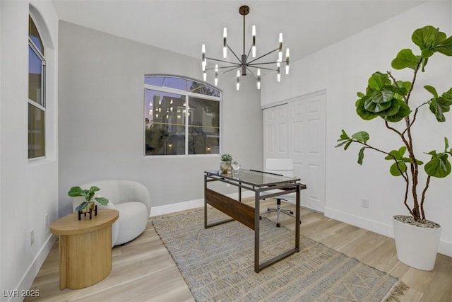 office space with light hardwood / wood-style flooring and an inviting chandelier