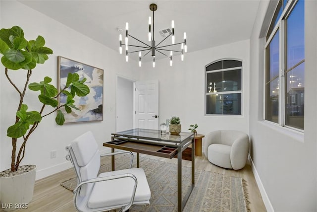 office featuring light wood-type flooring and a notable chandelier