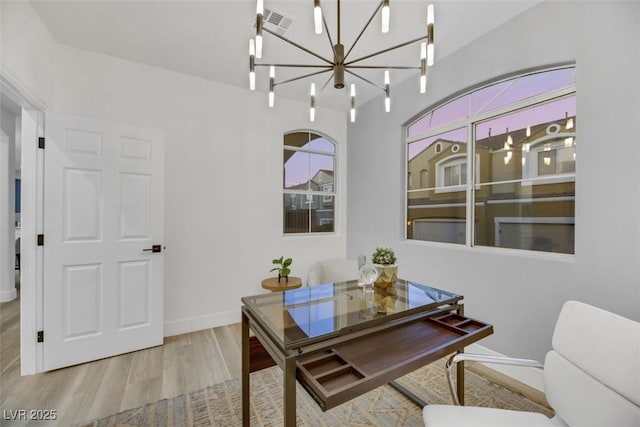 office space featuring wood-type flooring and an inviting chandelier