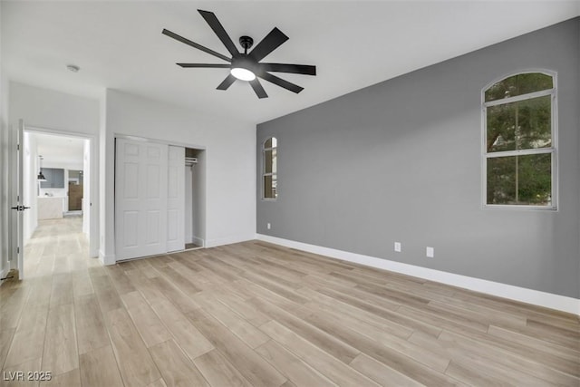 unfurnished bedroom featuring ceiling fan, a closet, and light hardwood / wood-style flooring