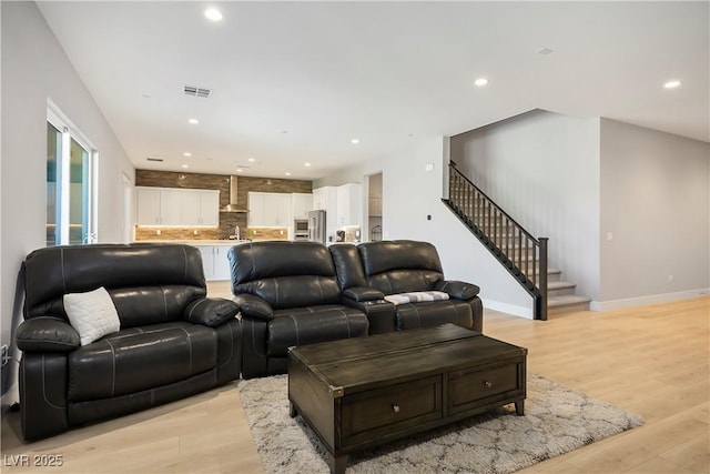 living room with light wood-type flooring and sink