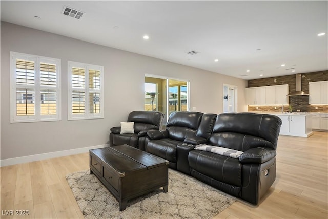 living room with a wealth of natural light and light hardwood / wood-style flooring