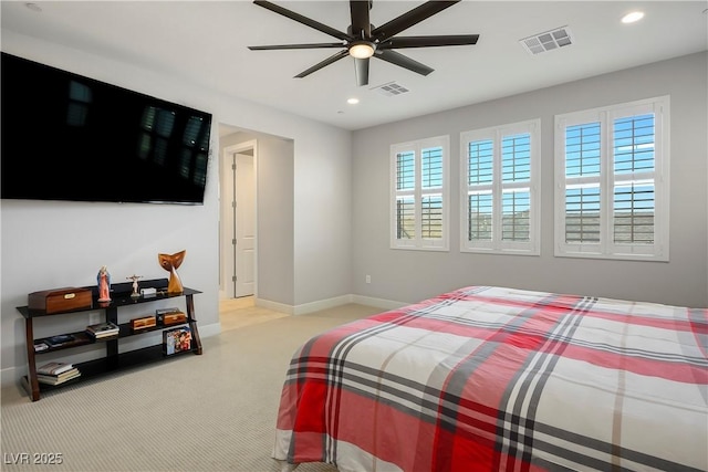 bedroom with multiple windows, ceiling fan, and light carpet