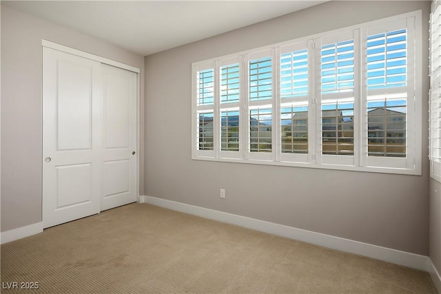 unfurnished bedroom with light carpet and a closet