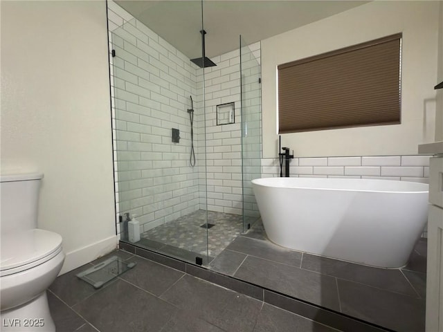 bathroom with plus walk in shower, tile patterned floors, toilet, and tile walls