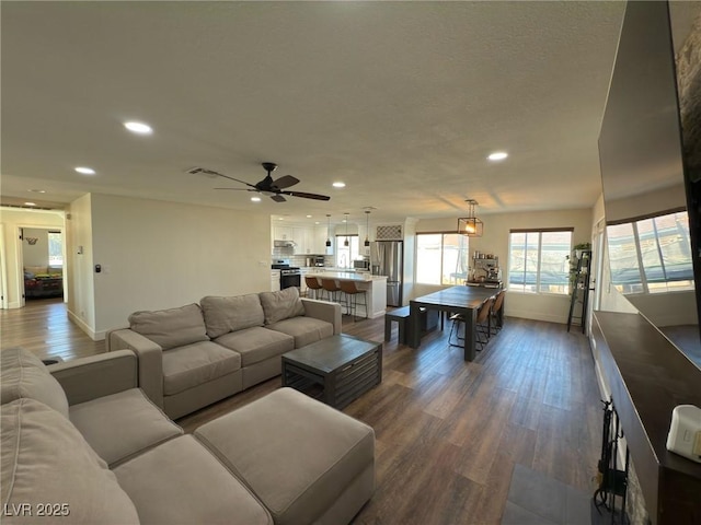 living room featuring ceiling fan and dark wood-type flooring