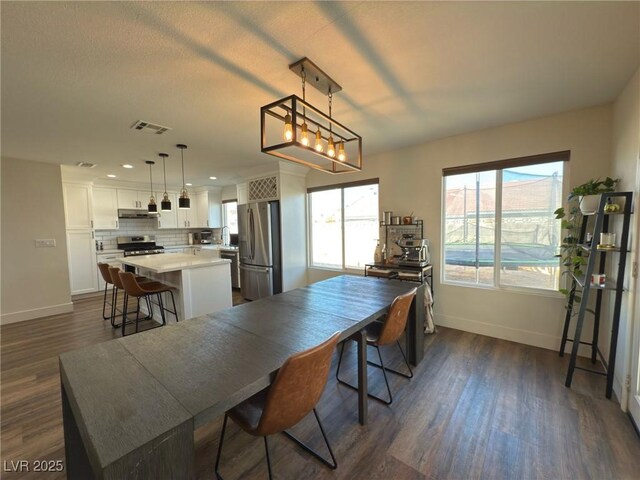 dining room with a healthy amount of sunlight, dark wood-type flooring, and sink