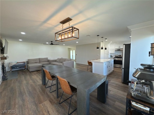 dining room with ceiling fan and dark hardwood / wood-style flooring