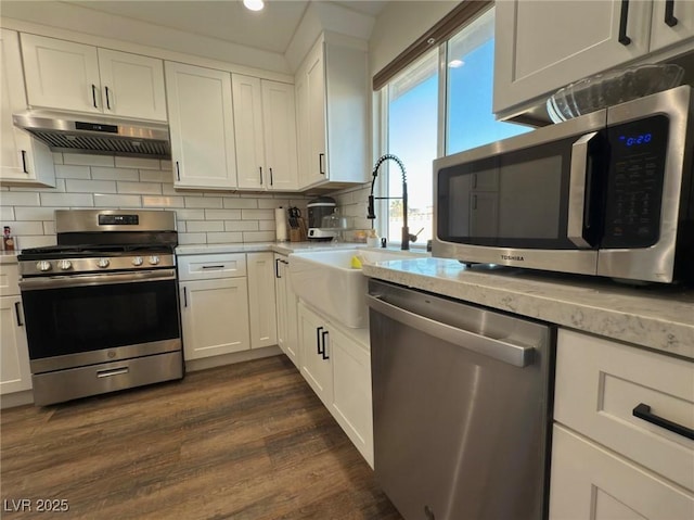 kitchen with sink, dark hardwood / wood-style flooring, backsplash, white cabinets, and appliances with stainless steel finishes