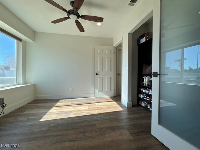 empty room with ceiling fan and dark wood-type flooring