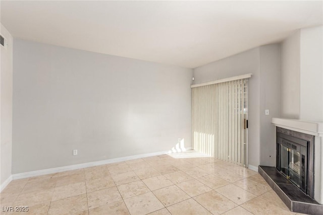 unfurnished living room with a tile fireplace and light tile patterned floors