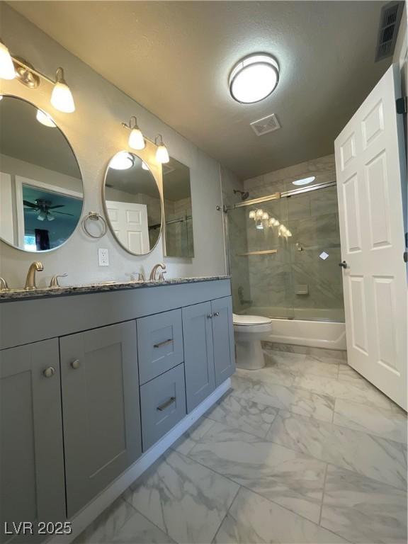 full bathroom with toilet, shower / bath combination with glass door, vanity, and ceiling fan