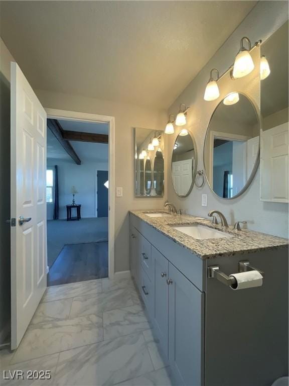 bathroom featuring beam ceiling and vanity