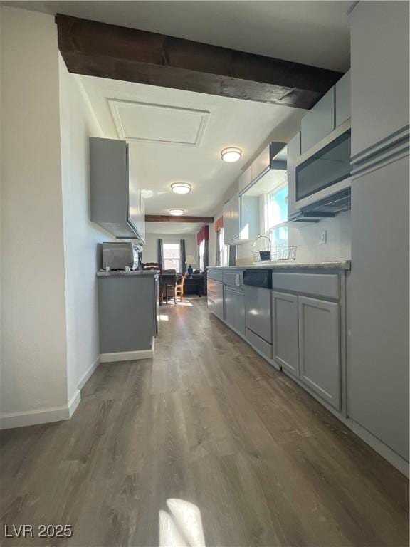 kitchen with stainless steel dishwasher and hardwood / wood-style floors