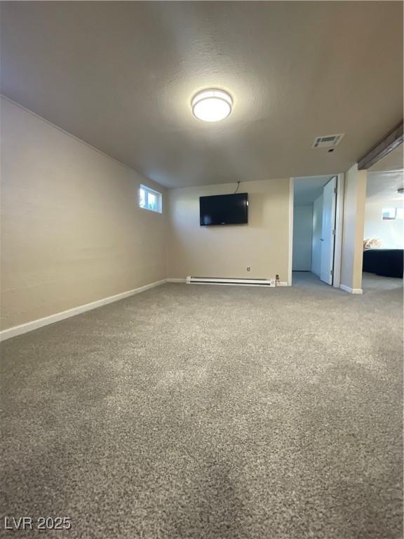 basement featuring a baseboard radiator and carpet