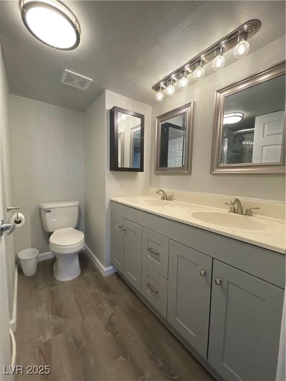 bathroom with toilet, an enclosed shower, vanity, and hardwood / wood-style floors