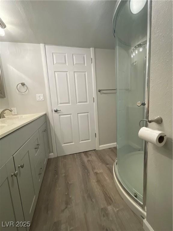 bathroom featuring vanity, wood-type flooring, and walk in shower