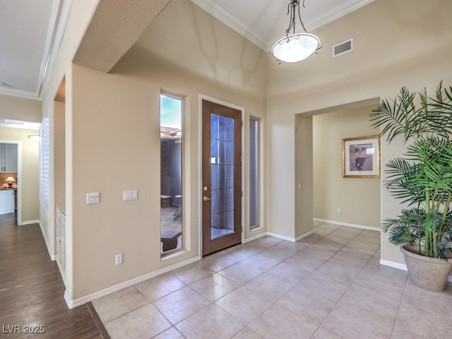 tiled foyer featuring crown molding