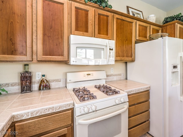 kitchen featuring white appliances and tile counters