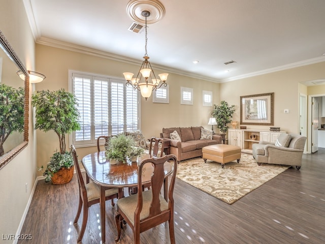 dining area featuring ornamental molding, a notable chandelier, and dark hardwood / wood-style floors