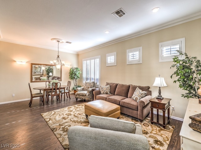 living room with a notable chandelier, ornamental molding, and dark hardwood / wood-style floors