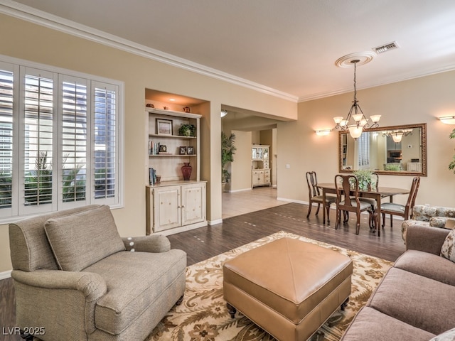 living room featuring an inviting chandelier, hardwood / wood-style flooring, and crown molding