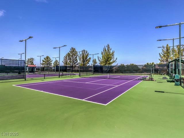 view of tennis court featuring basketball hoop