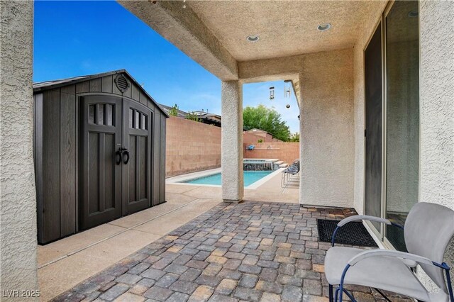 view of patio with a fenced in pool and a shed