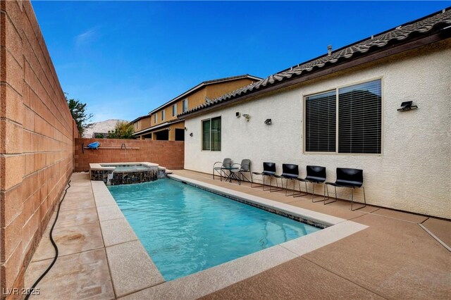 view of pool featuring a patio and an in ground hot tub