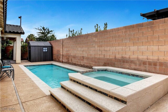 view of swimming pool featuring an in ground hot tub and a shed