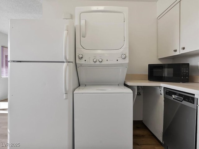 laundry room with dark wood-type flooring and stacked washer and clothes dryer