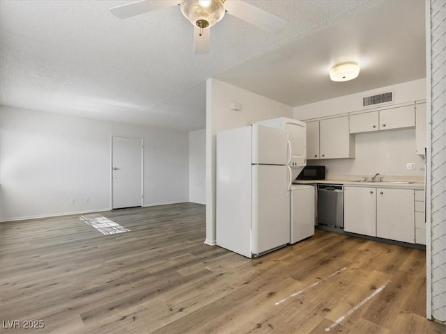 kitchen with white refrigerator, sink, white cabinets, dishwasher, and ceiling fan