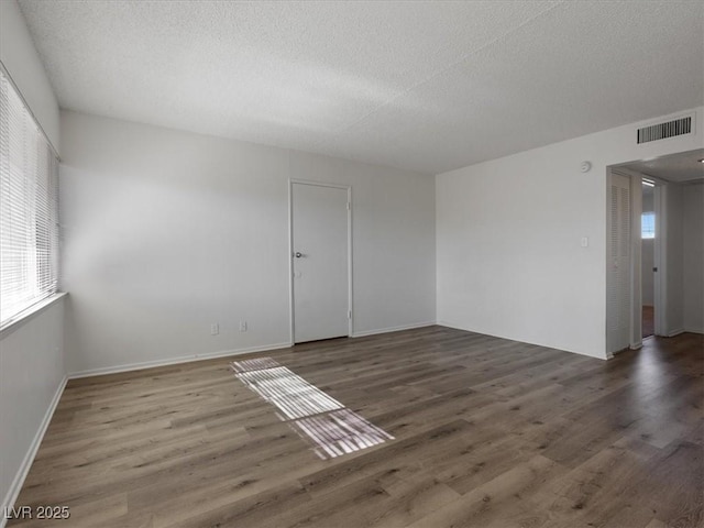 unfurnished room featuring a textured ceiling and dark wood-type flooring