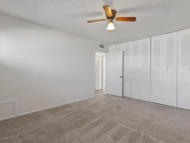 unfurnished bedroom featuring a closet, a textured ceiling, ceiling fan, and light colored carpet