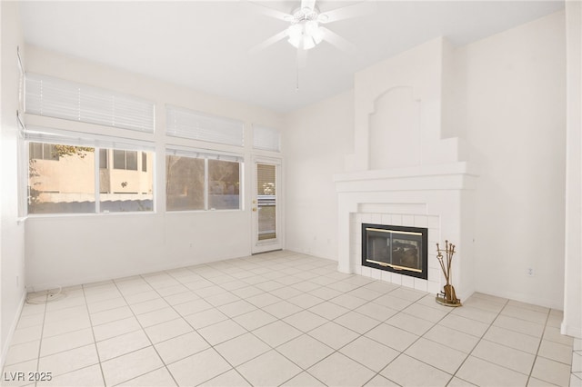 unfurnished living room featuring a tile fireplace, ceiling fan, and light tile patterned floors